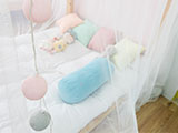 A child's bed covered with a mosquito net.